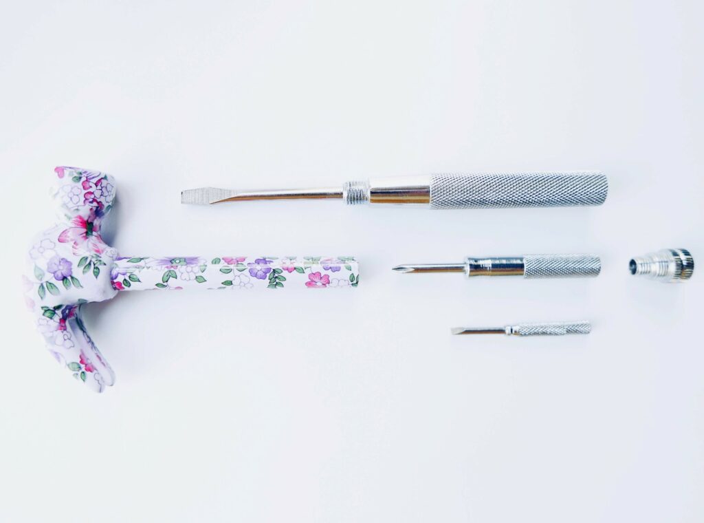 Un marteau plein de couleur est posé avec 3 tournevis 